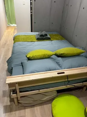a bed in a room with yellow pillows on it at Green Apple Otsuka 201 in JR Otsuka station in Tokyo