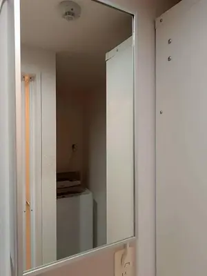 a mirror hanging on a wall in a bathroom at Green Apple Otsuka 201 in JR Otsuka station in Tokyo