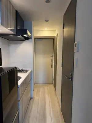 a kitchen with a hallway leading to a door at Artessimo\u62bc\u4e0a 401 in Tokyo