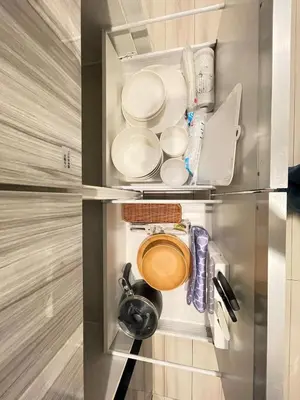 a refrigerator with plates and utensils in it at Artessimo\u62bc\u4e0a 401 in Tokyo