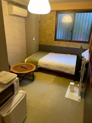 a bedroom with a bed and a table and a tv at Asakusa Retreat Designer curated stylish room 1 in Tokyo