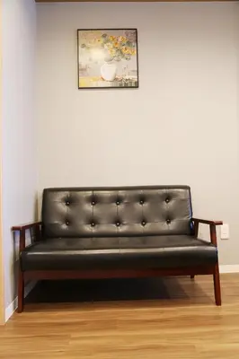 a black leather couch against a white wall with a painting at M207 Easy access to Ikebukuro Red Leaves ,Golden Ginkgo in Tokyo