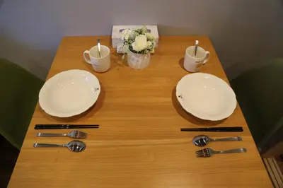 a wooden table with two plates and forks and spoons at M207 Easy access to Ikebukuro Red Leaves ,Golden Ginkgo in Tokyo