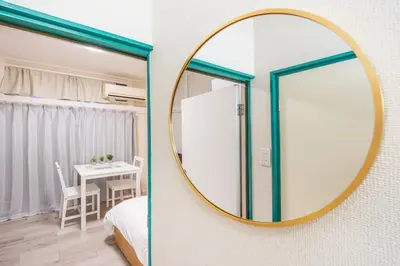 a mirror on a wall with a bedroom and a table at 7 min to JR Otsuka,Direct Yamanote Line ,1 stop to Ikebukuro,Direct to Shinjuku ,Shibuya,Fully Renovated,18 sqm,2 Guests #101 in Tokyo