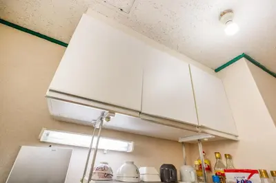 a kitchen with white cabinets and a green line on the ceiling at 7 min to JR Otsuka,Direct Yamanote Line ,1 stop to Ikebukuro,Direct to Shinjuku ,Shibuya,Fully Renovated,18 sqm,2 Guests #101 in Tokyo