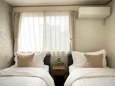 two beds sitting in a room with a window at SK - Tokyo Ikebukuro Premium Comfort 4LDK Entire house in Tokyo