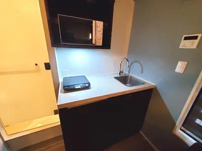 a small kitchen with a sink and a microwave at \u30b3\u30f3\u30c6\u30eb\u897f\u4e94\u53cd\u7530303 in Tokyo