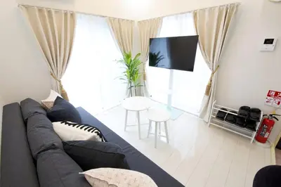 a living room with a blue couch and a tv at \u738b\u5b50\u795e\u8c37\u5e73\u5c4b in Tokyo