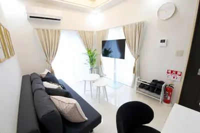 a living room with a couch and a tv at \u738b\u5b50\u795e\u8c37\u5e73\u5c4b in Tokyo
