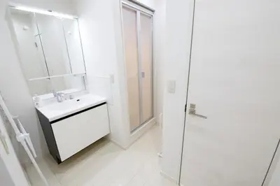 a white bathroom with a sink and a shower at \u738b\u5b50\u795e\u8c37\u5e73\u5c4b in Tokyo