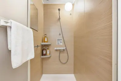 a bathroom with a shower with a glass door at Silvership Hotel 101 in Tokyo