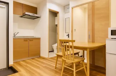 a small kitchen with a wooden table in a room at Silvership Hotel 101 in Tokyo