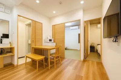 a room with a table and chairs and a television at Silvership Hotel 101 in Tokyo