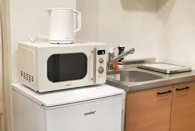 a microwave sitting on top of a refrigerator in a kitchen at Silvership Hotel 101 in Tokyo