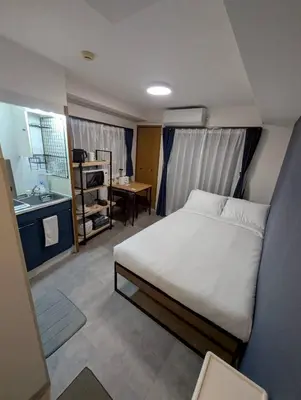 a small bedroom with a bed and a kitchen at CraftFlat Numabukuro 307, uphill residence in Tokyo