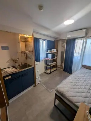 a bedroom with a bed and a sink and a kitchen at CraftFlat Numabukuro 307, uphill residence in Tokyo
