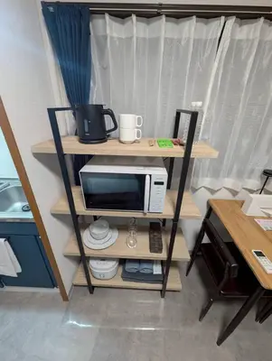 a microwave on a shelf in a room at CraftFlat Numabukuro 307, uphill residence in Tokyo