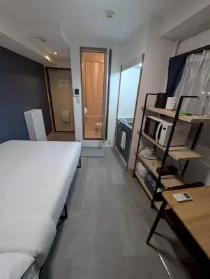 a bedroom with a large bed and a table and a desk at CraftFlat Numabukuro 307, uphill residence in Tokyo