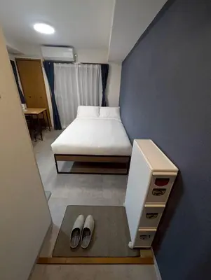a small bedroom with a bed and a desk at CraftFlat Numabukuro 307, uphill residence in Tokyo