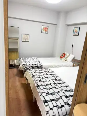 a row of beds in a room with white walls at \u9e1f\u8d8a201\u6210\u7530\u7fbd\u7530\u673a\u573a\u53ef\u76f4\u8fbe\u4ea4\u901a\u4fbf\u5229\u5e02\u4e2d\u5fc3 in Tokyo