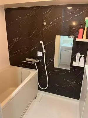 a bathroom with a white tub and a black marble wall at \u9e1f\u8d8a201\u6210\u7530\u7fbd\u7530\u673a\u573a\u53ef\u76f4\u8fbe\u4ea4\u901a\u4fbf\u5229\u5e02\u4e2d\u5fc3 in Tokyo