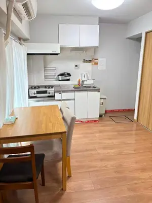 a kitchen with white cabinets and a wooden table at \u9e1f\u8d8a201\u6210\u7530\u7fbd\u7530\u673a\u573a\u53ef\u76f4\u8fbe\u4ea4\u901a\u4fbf\u5229\u5e02\u4e2d\u5fc3 in Tokyo
