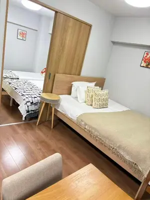 a bedroom with two beds and a table in it at \u9e1f\u8d8a201\u6210\u7530\u7fbd\u7530\u673a\u573a\u53ef\u76f4\u8fbe\u4ea4\u901a\u4fbf\u5229\u5e02\u4e2d\u5fc3 in Tokyo