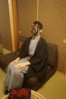 a man wearing a mask sitting in a chair at WA NO YADO-Asakusa Designer curated stylish room 2 in Tokyo