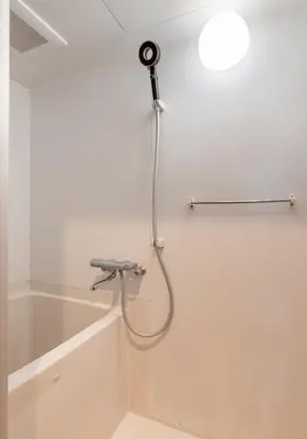 a shower with a hose attached to a wall at WA NO YADO-Asakusa Designer curated stylish room 2 in Tokyo