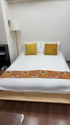 a large bed with a wooden frame in a room at \u9e1f\u8d8a101\u6210\u7530\u7fbd\u7530\u673a\u573a\u76f4\u8fbe\u5e02\u4e2d\u5fc3\u4ea4\u901a\u65b9\u4fbf\u53ef\u6b65\u884c\u62b5\u8fbe\u79cb\u53f6\u539f in Tokyo