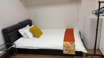 a bedroom with a bed with a black headboard at \u9e1f\u8d8a101\u6210\u7530\u7fbd\u7530\u673a\u573a\u76f4\u8fbe\u5e02\u4e2d\u5fc3\u4ea4\u901a\u65b9\u4fbf\u53ef\u6b65\u884c\u62b5\u8fbe\u79cb\u53f6\u539f in Tokyo