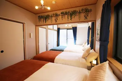 a bedroom with two beds and a window at Haku Nest Ichinoe in Tokyo