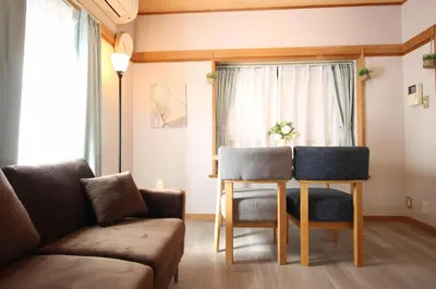a living room with a couch and a table and chairs at Haku Nest Ichinoe in Tokyo