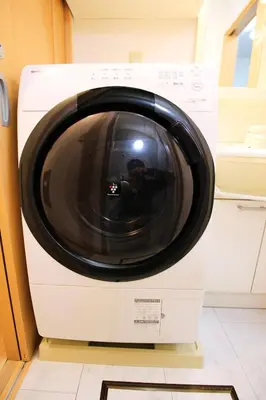 a white washing machine is sitting on a shelf at Haku Nest Ichinoe in Tokyo