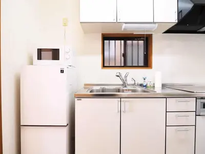 a white kitchen with a sink and a refrigerator at Haku Nest Ichinoe in Tokyo