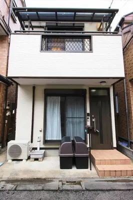 a house with two chairs sitting on the front porch at Haku Nest Ichinoe in Tokyo