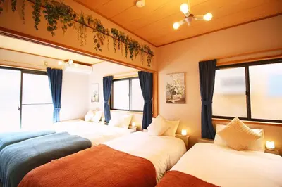 a bedroom with two beds and two windows at Haku Nest Ichinoe in Tokyo