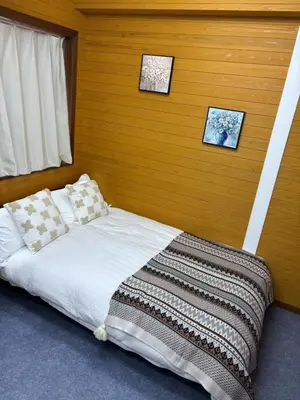 a bed in a room with two pictures on the wall at \u9e1f\u8d8a102\u6210\u7530\u7fbd\u7530\u673a\u573a\u76f4\u8fbe\u6b65\u884c8\u5206\u949f\u53ef\u62b5\u8fbe\u6c11\u5bbf\u4f4d\u7f6e\u4f18\u8d8a in Tokyo