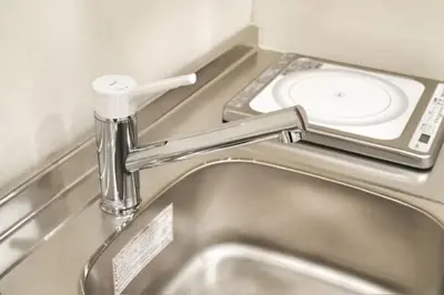 a metal sink in a bathroom with a toilet at Silvership Hotel 401 in Tokyo