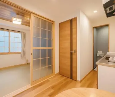 a kitchen with a large wooden door in a room at Silvership Hotel 402 in Tokyo