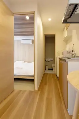 a room with a kitchen and a bedroom with a bed at Silvership Hotel 402 in Tokyo
