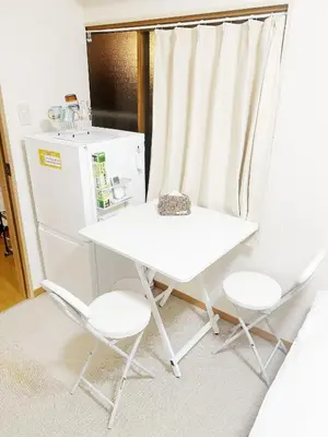 a white table and two chairs and a refrigerator at 501Room,Elevator to the 5th Floor Two Bedroom Apartment Near Tokyo Tower with Direct Train Access to Haneda Narita Airports and Asakusa in Tokyo