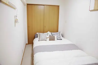 a small bedroom with two beds in a room at 501Room,Elevator to the 5th Floor Two Bedroom Apartment Near Tokyo Tower with Direct Train Access to Haneda Narita Airports and Asakusa in Tokyo