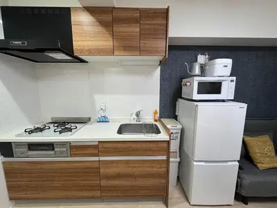 a small kitchen with a sink and a microwave at Moto Sakura 403,2 bedrooms with 4 beds, 6 people, direct access to Narita and Haneda Airports, Asakusa and Ueno area, 5 train lines available, Bicycles free rental in Tokyo
