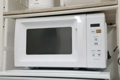 a white microwave oven sitting on top of a shelf at Shinbashi Oliver in Tokyo