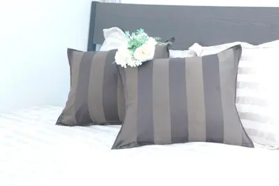 a bed with gray pillows with a flower on it at #3 Tokyo Shinjuku Shibuya room in Tokyo