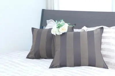 a bed with gray and white pillows with a flower on it at #3 Tokyo Shinjuku Shibuya room in Tokyo