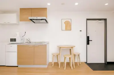 a kitchen with a table and stools in a room at Silvership Hotel 302 in Tokyo