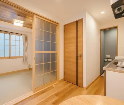 a kitchen with a large wooden door in a room at Silvership Hotel 302 in Tokyo