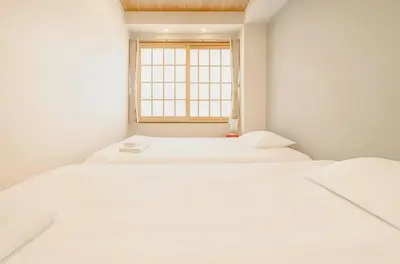 two white beds in a room with a window at Silvership Hotel 302 in Tokyo